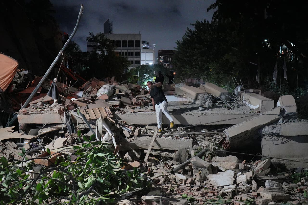 Un hombre salta sobre un edificio derrumbado tras un terremoto en Caracas.