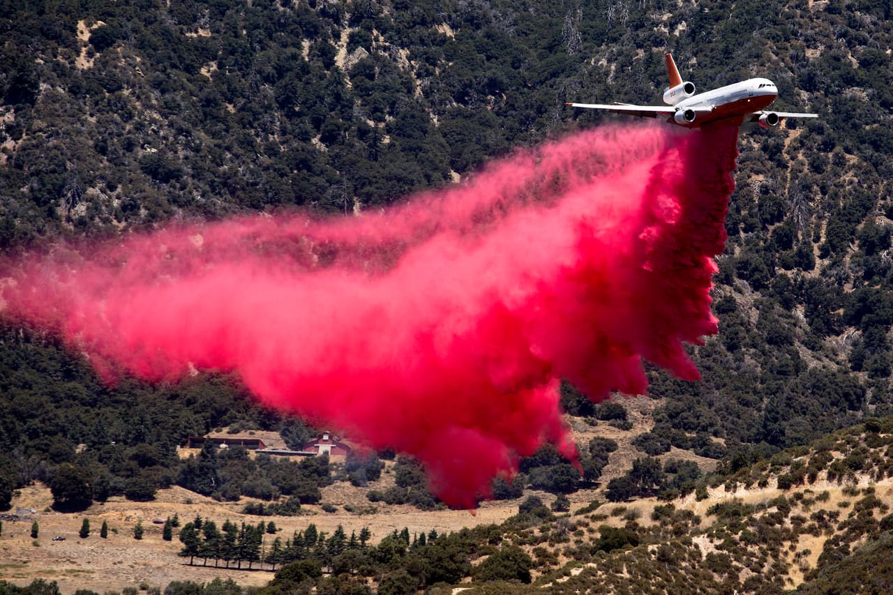 Un avión cisterna lanza un retardador de fuego en el Apple Fire en Cherry Valley, California, el sábado 1 de agosto de 2020.