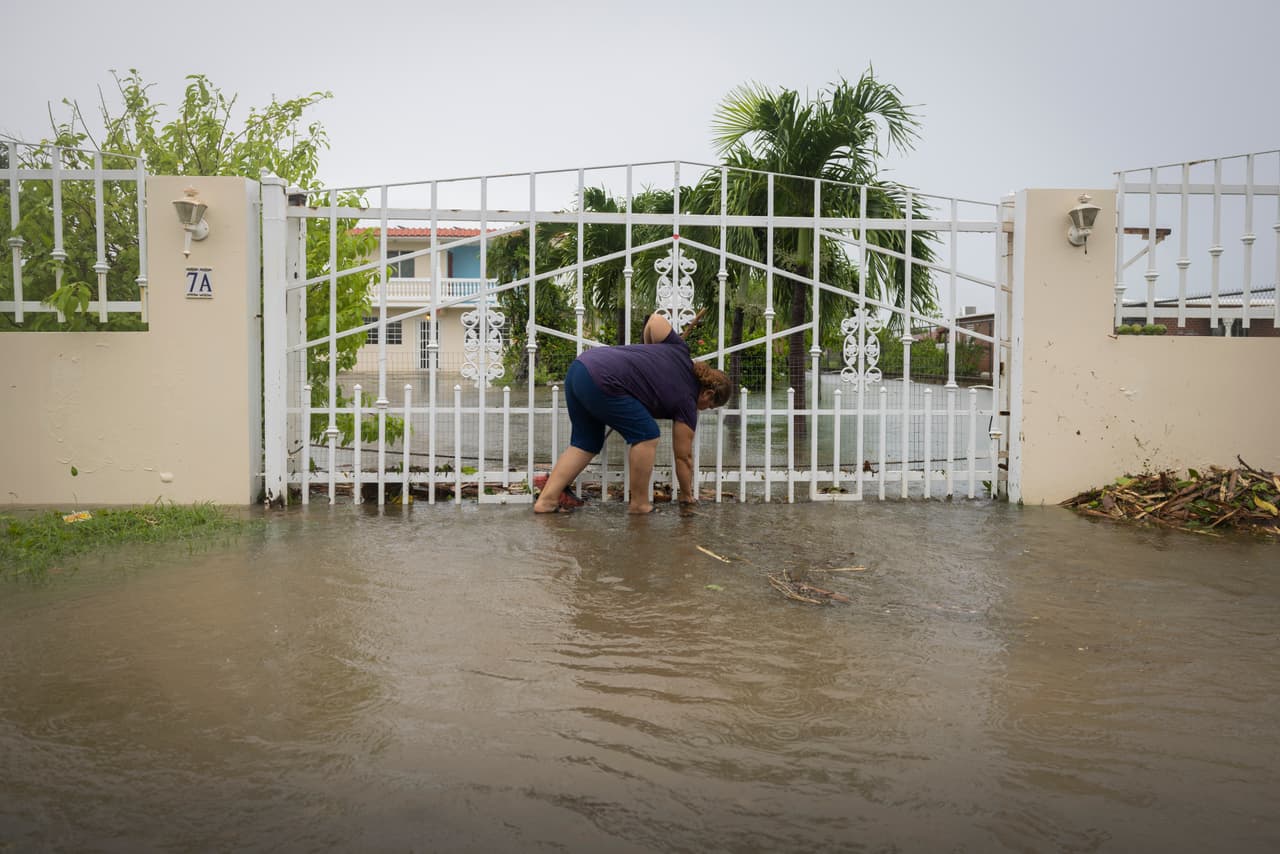 Una residente de Salinas saca los escombros de su casa inundada por el huracán Fiona.