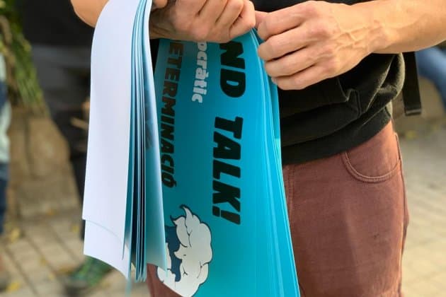 Los grupos de Tsunami Democàtic ya se reunen para protestar camino al Camp Nou. El movimiento independentista cuenta con 100 mil cartulinas con el lema 'Spain, sit and talk', mismas que reparten a la gente para ser mostradas después del himno del Barça.