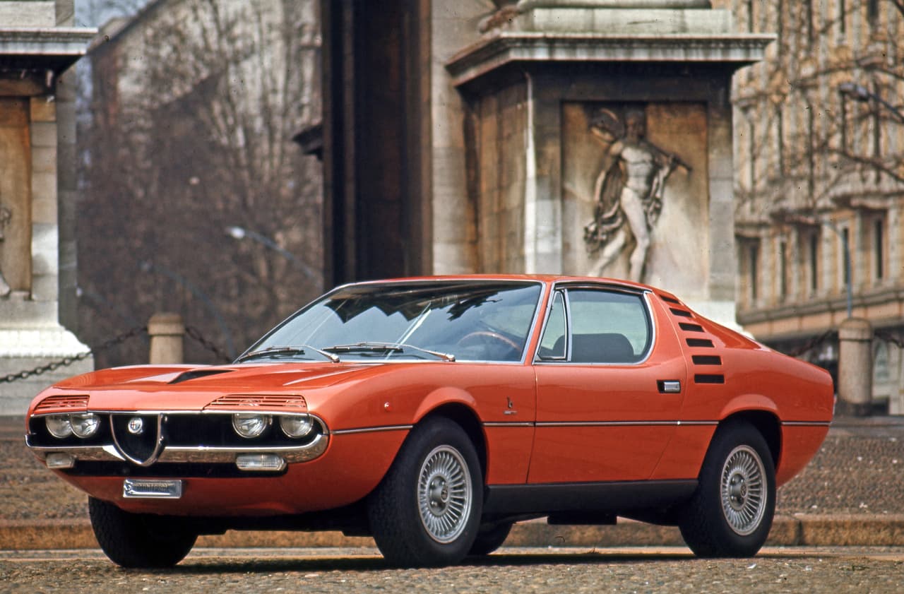 En 1970 aparecía el Alfa Romeo Montreal, el cual fue presentado inicialmente como un prototipo en 1967 en forma de un coupe 2+2 usando el motor 1.6 litros del Giulia Sprint GT y diseño de Marcello Gandini (Bertone). En esta foto vemos el Alfa Romeo Montreal de 1970, según Alfa Romeo “la máxima aspiración de la época”.