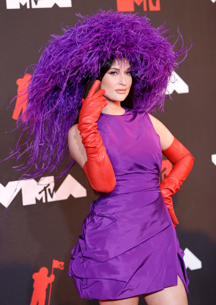 La cantante de "Star-Crossed" se veía absolutamente fabulosa con su mini sombrero violeta brillante y su sombrero de plumas a juego.