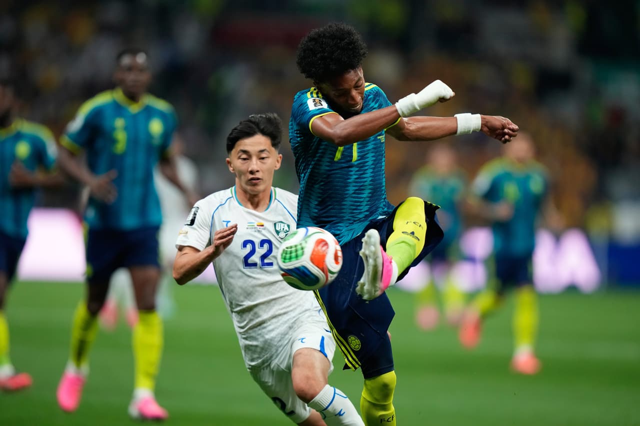Johan Mojica (17) de Colombia patea el balón contra Abbosbek Fayzullaev (22) de Uzbekistán durante el partido de fútbol del Grupo K de la Copa Mundial entre Uzbekistán y Colombia en CDMX.