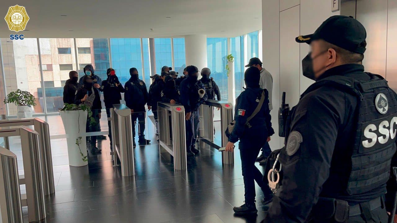 Policías de la Ciudad de México al realizar un operativo a uno de los 12 imuebles para dar con una red de estafadores a través de aplicaciones móviles el 17 de agosto de 2022.