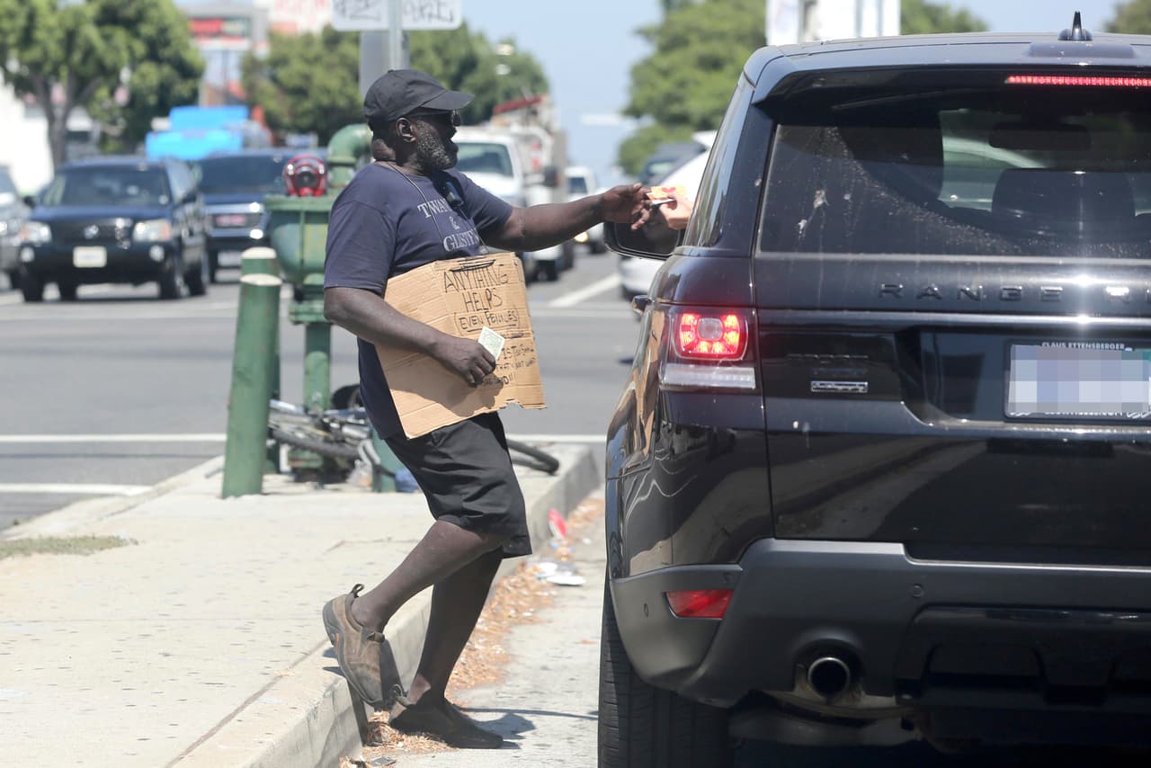 Aquí vemos a Gigi Hadid siendo caritativa. La super modelo le entrega algunas tarjetas de regalo a un indigente a través de la ventana de su Range Rover Sport Autobiography de 
<b>94,950 dólares</b>.