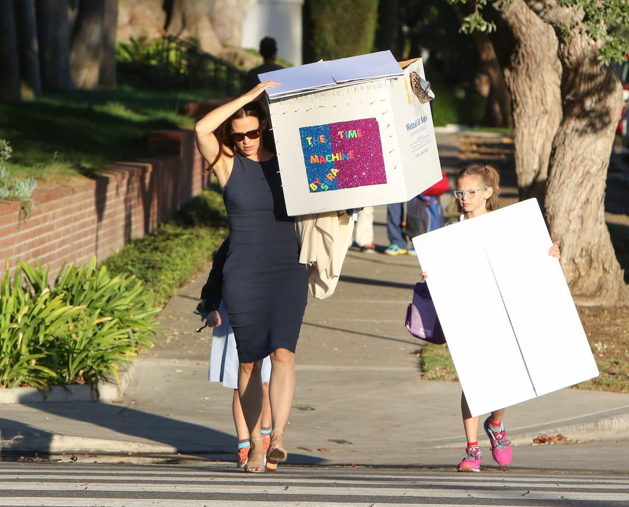 Y es que recién sale esta imagen de Jen cargando esta cajota, que simboliza una "máquina de tiempo" hecha por su hijita Seraphina.