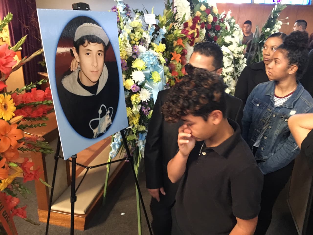 Un adolescente llora frente a una imagen del chico que fue hallado en una canalización del río Los Ángeles.