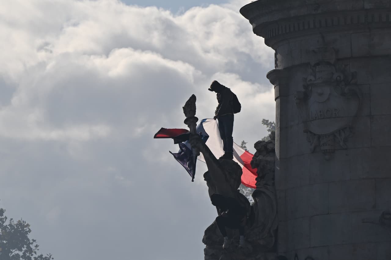 Un manifestante sostiene una bandera francesa en la plaza de la República durante una protesta contra el aumento del costo de vida y en solidaridad con las reivindicaciones estudiantiles en Lyon, Francia, el sábado 17 de octubre de 2026.