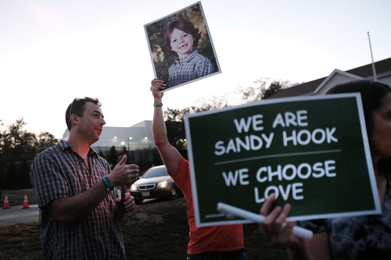 NEWTOWN, CT - OCTOBER 04: Mark Barden holds up a picture of his son Daniel who was killed in the Sandy Hook masracre during a vigil remembering the 58 people killed in Sunday's shooting in Las Vegas and calling for action against guns on October 4, 2017 in Newtown, Connecticut. The vigil, organized by the Newtown Action Alliance, was held outside the National Shooting Sport Foundation and looked to draw attention to gun violence in America. Twenty school children were killed at the Sandy Hook Elementary School shooting on December 14, 2012. (Photo by Spencer Platt/Getty Images)