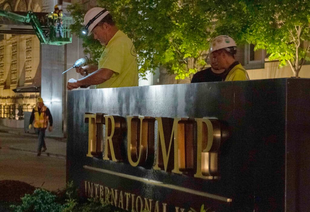 Trabajadores quitan el nombre de Trump International en la placa frente al famoso hotel, tras completarse la operación de compra-venta.