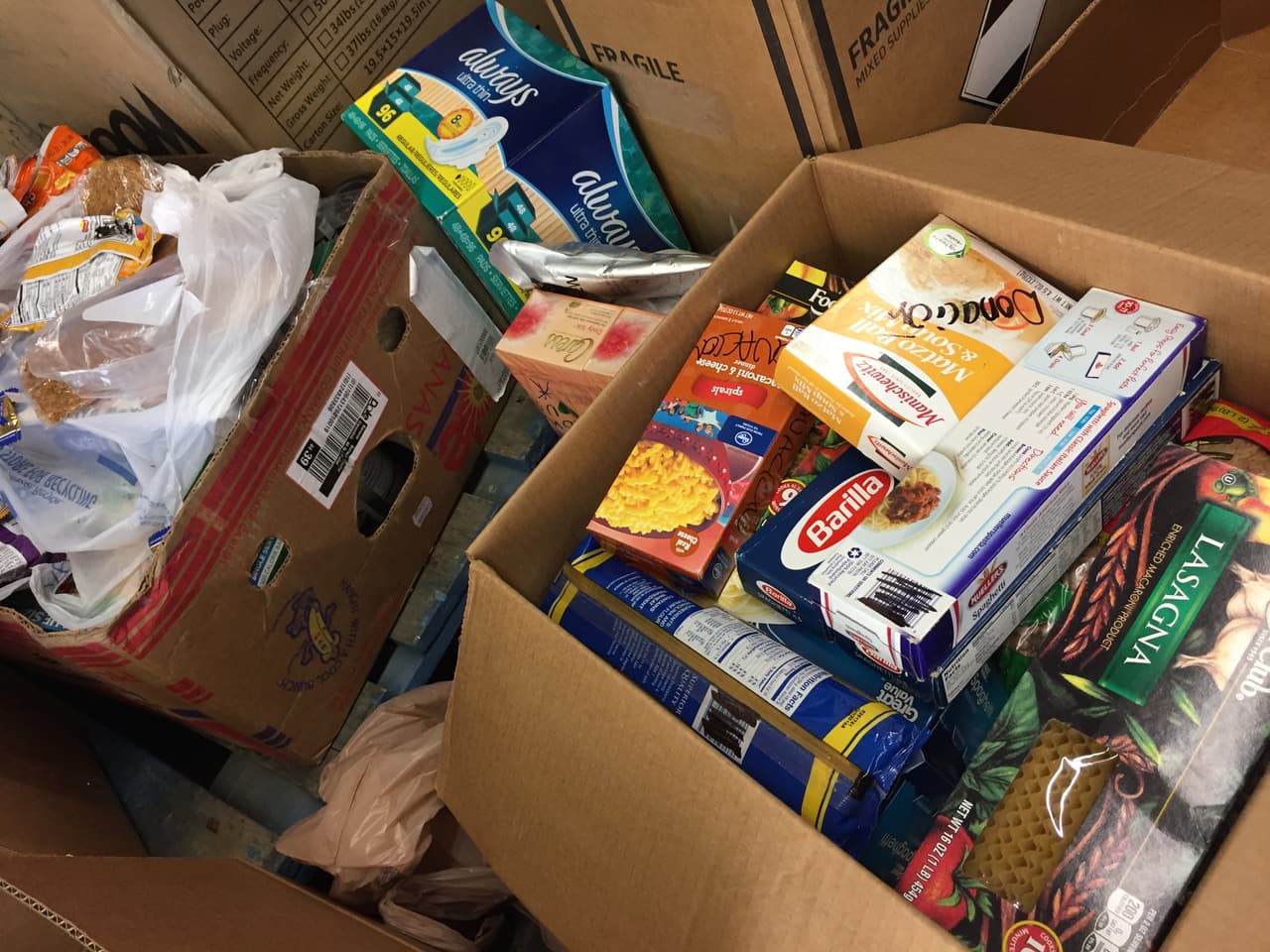 Cajas con comida y artículos de aseos llenas en el cernto de acopio de Tucson.