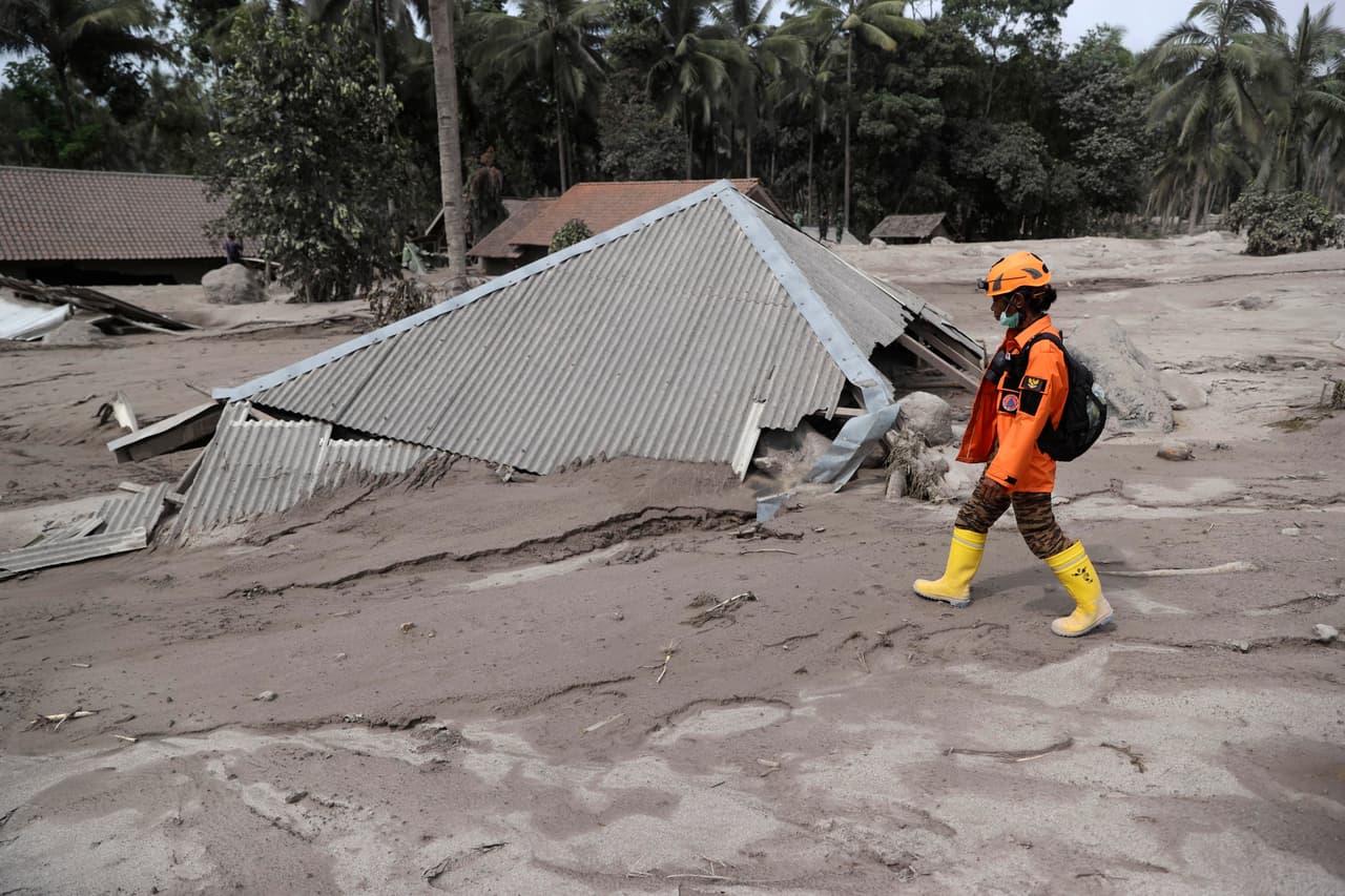 El lunes mejoraron las condiciones meteorológicas y eso permitió la reanudación de la búsqueda de cadáveres. 
<br>
<br>En la foto un rescatista camina sobre una casa cubierta con ceniza en el distrito de Lumajang, en la isla de Java.
