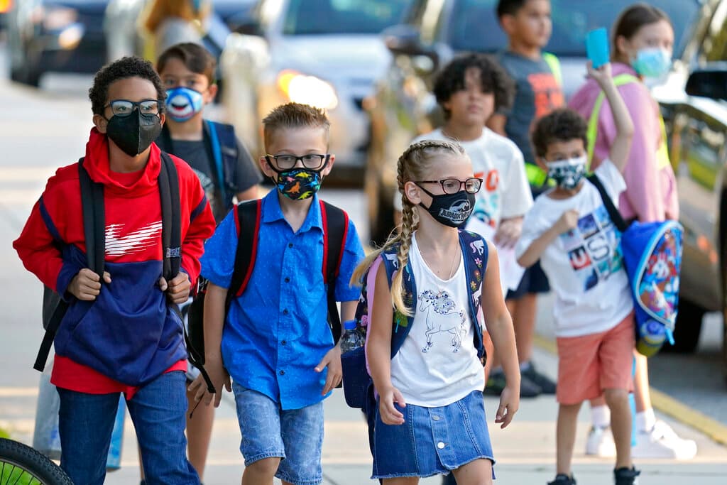 En esta fotografía de archivo del martes 10 de agosto de 2021, estudiantes, algunos con máscaras protectoras, llegan para el primer día de clases en la Escuela Primaria Sessums en Riverview, Florida.
