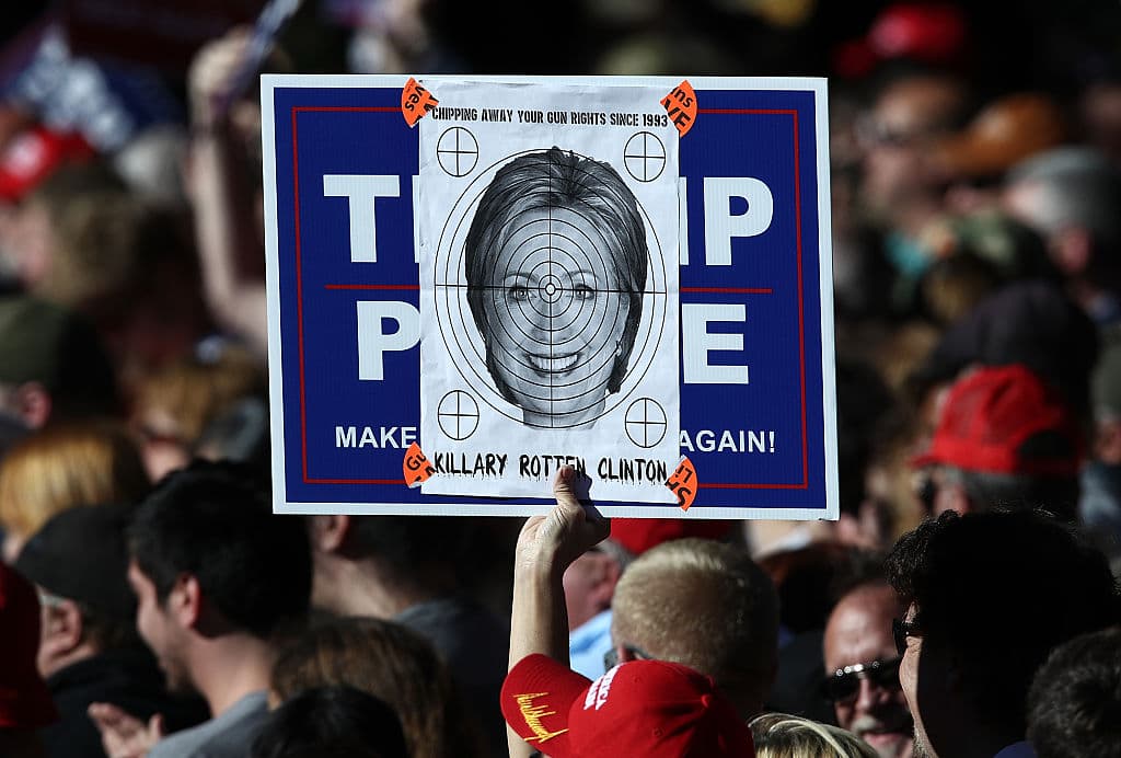 Un seguidor de Trump sostiene una foto de Clinton con una diana superpuesta durante un mitin de Trump en Virginia Beach, Virginia.