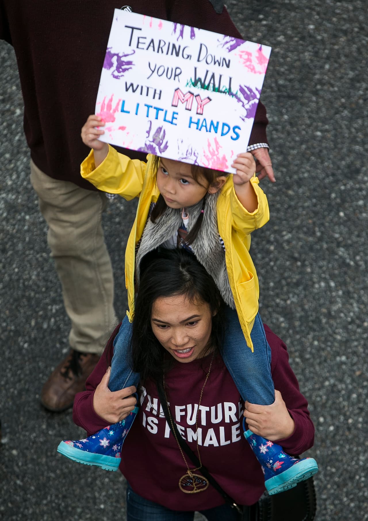 “Derribando tu muro con mis diminutas manos”, declara la pancarta de esta pequeña participante.