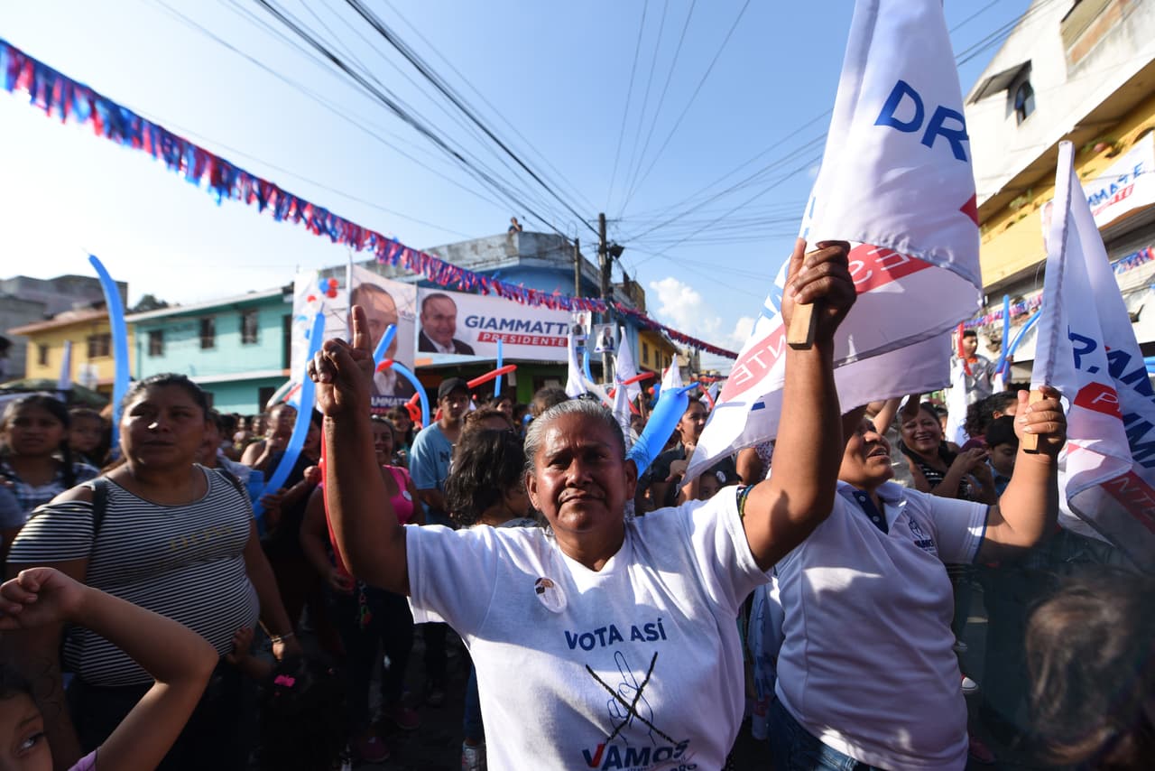 Partidarios del candidato de Vamos, Alejandro Giammattei, ondean banderas del partido en un acto de campaña en Ciudad de Guatemala.