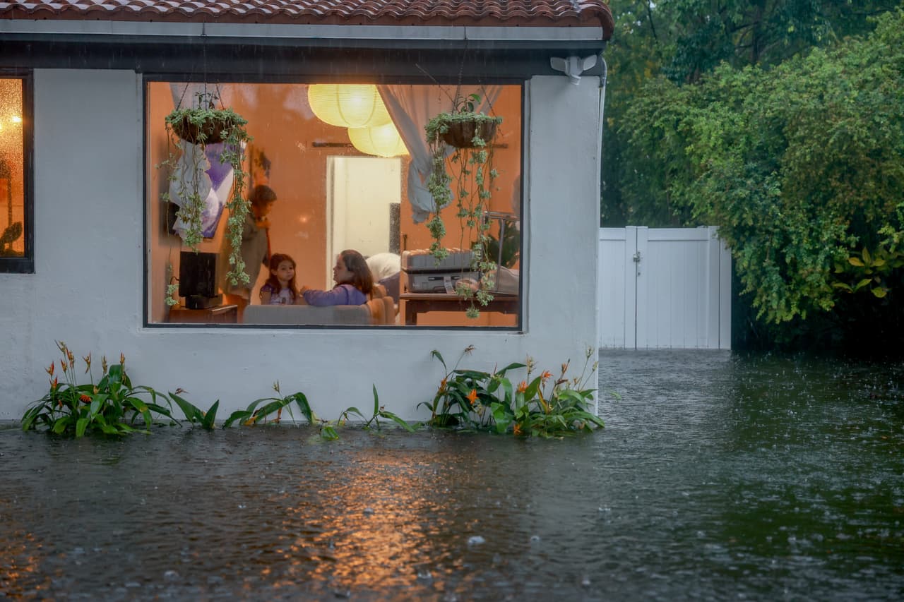 Las personas en sus casas observaban cómo el agua se metía en sus hogares.