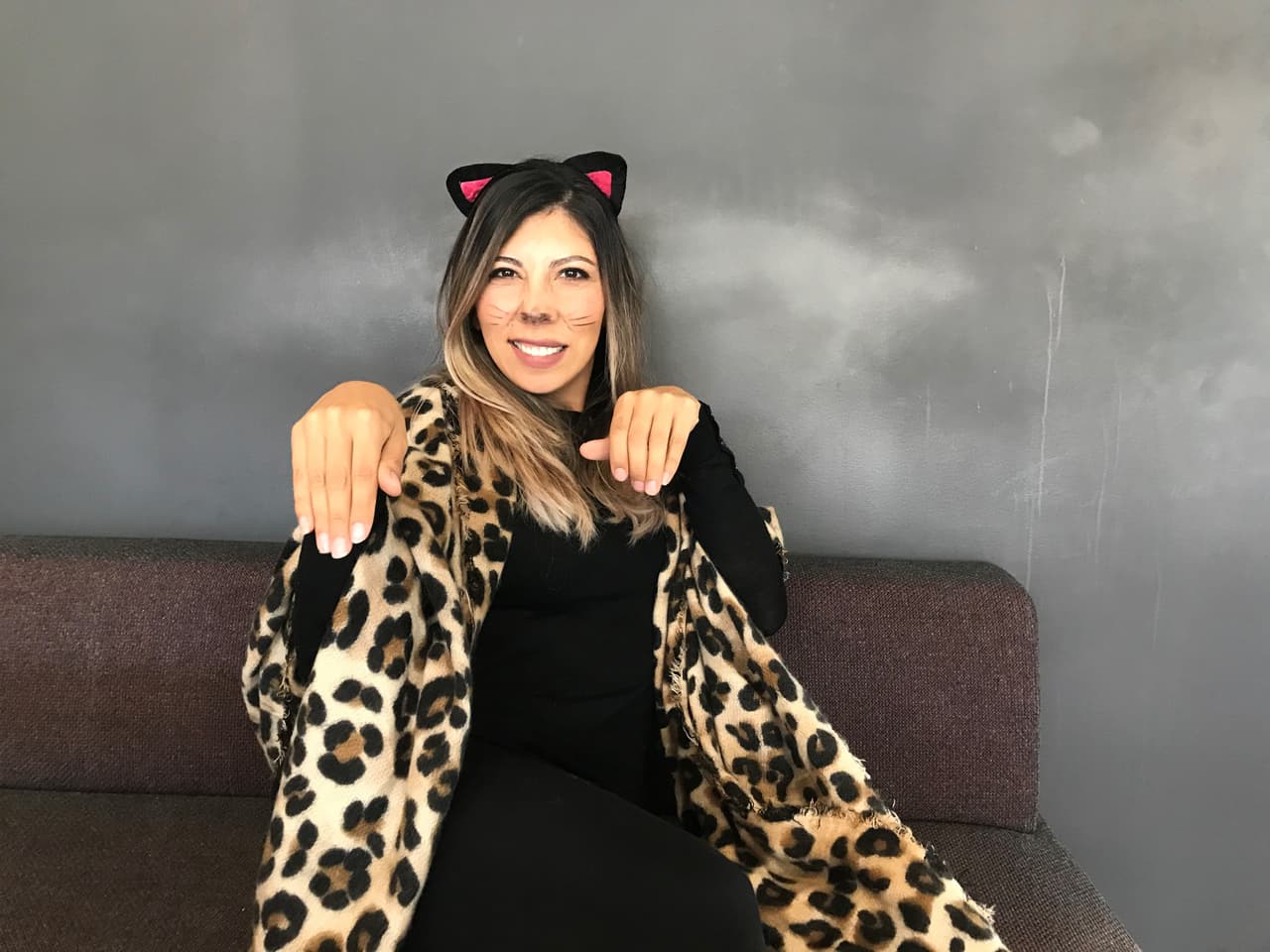 Marina Gutiérrez, Ejecutiva de Ventas, alza sus manos hacia la cámara y le gruñe, imitando los gestos de un felino.