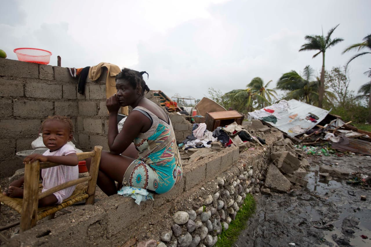 A woman and her daughter in the ruins of their home in Les Cayes, Haití.