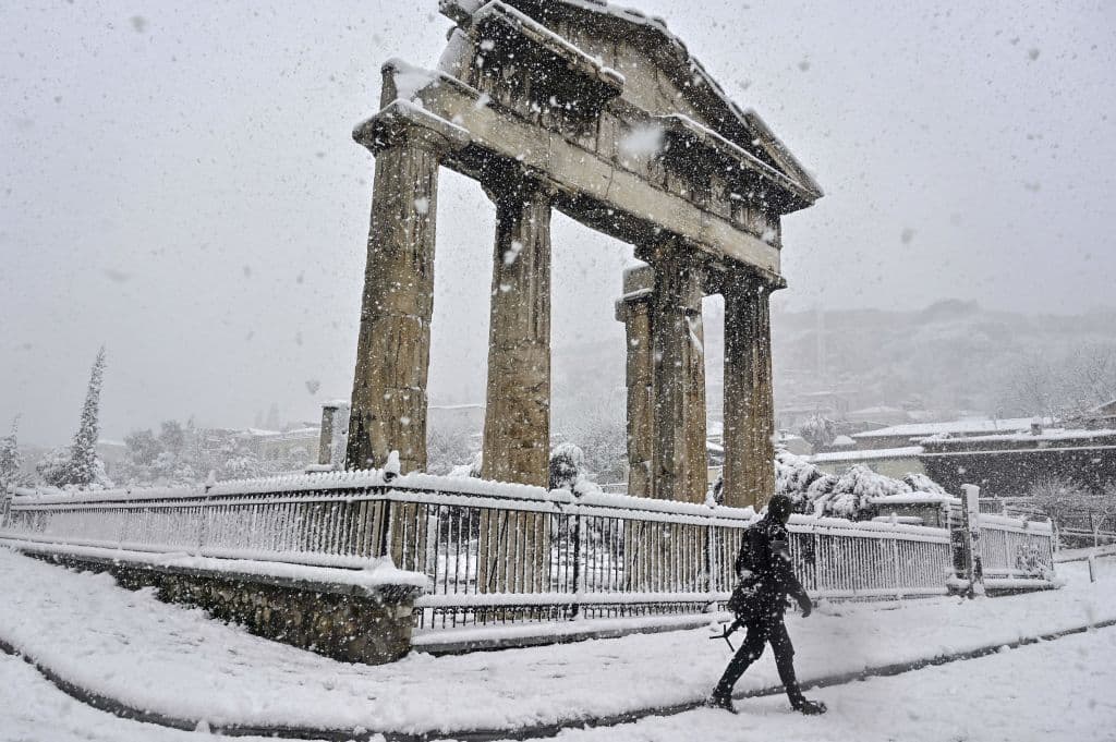 <b>Un hombre pasa junto al Ágora romana</b> durante las fuertes nevadas sobre Atenas. Los potentes vientos obligaron a los barcos que unen Atenas con las islas de mar Egeo a permanecer en puerto. 
<b>Se registraron ráfagas de más de 55.92 mph (100km/h). </b>
<br>
<br>
