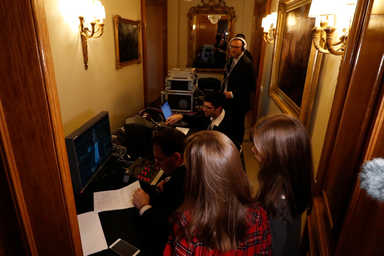 Las infantas observan con atención la grabación del mensaje de Navidad que realizan funcionarios públicos y se distribuye posteriormente para su emisión en las cadenas de televisión del país.