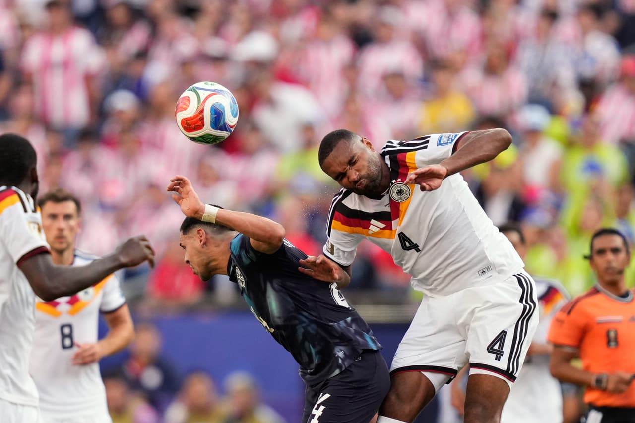 El alemán Jonathan Tah (derecha) salta para disputar el balón con el paraguayo Gustavo Caballero durante el partido de dieciseisavos de final de la Copa del Mundo entre Alemania y Paraguay en Foxborough, Massachusetts, cerca de Boston, el lunes 29 de junio de 2026.