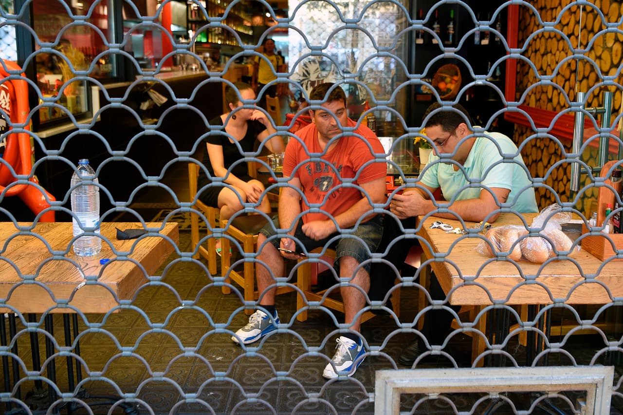 Mucha gente se refugió en comercios de la zona, cuyos empleados y dueños cerraron por seguridad. Personas que paseaban por la tarde en la Rambla sentadas en un bar detrás de una cortina de hierro.