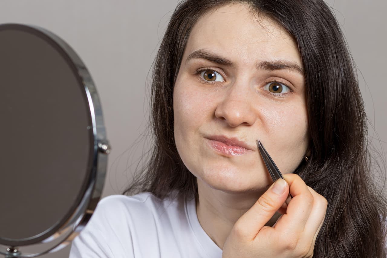 Mujer depilando su labio.