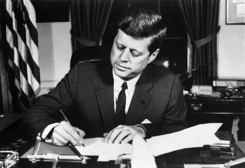 El presidente John F. Kennedy firmando la orden de bloqueo naval a Cuba en la casa Blanca.