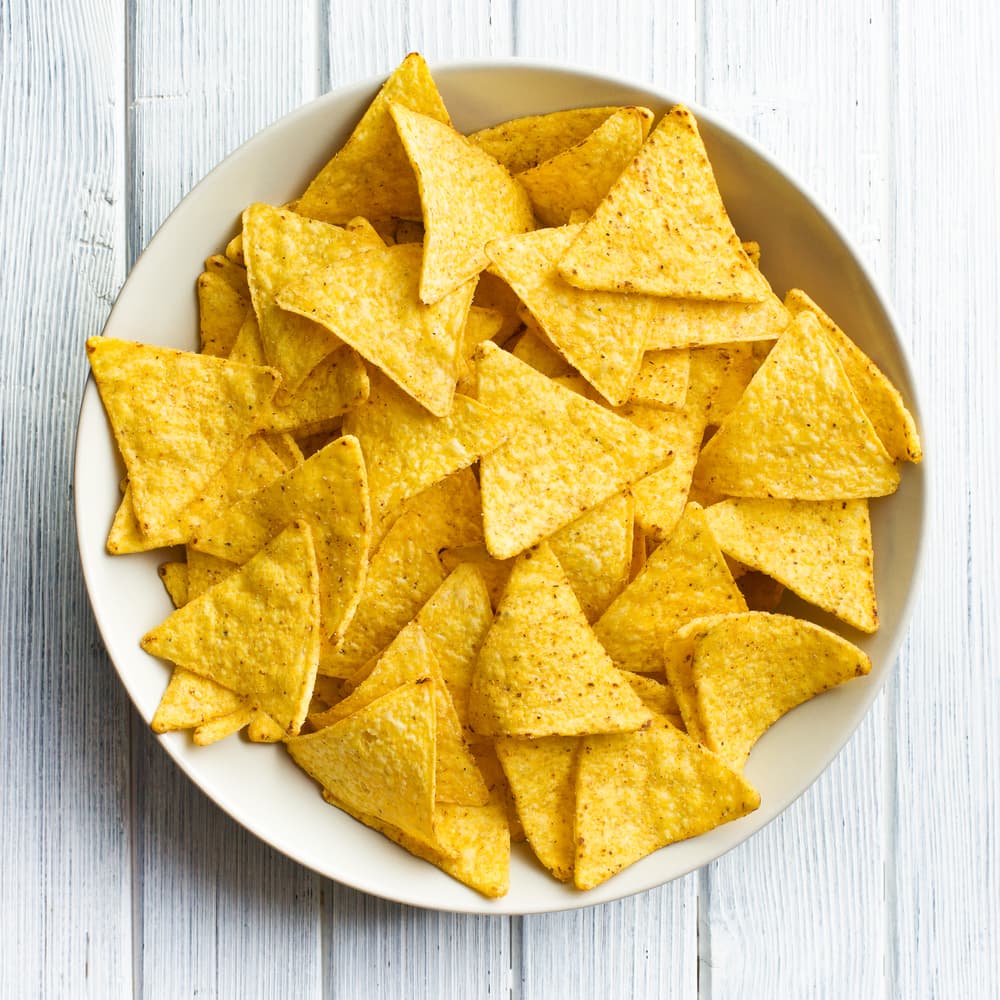 Para la salsa de queso necesitas 2 cucharadas de mantequilla, 2 cucharadas de harina, 2 tazas de leche y 3/4 de libra de queso. Lo mejor de los nachos es la facilidad para prepararlos acomoda los totopos en un plato grande para servir.