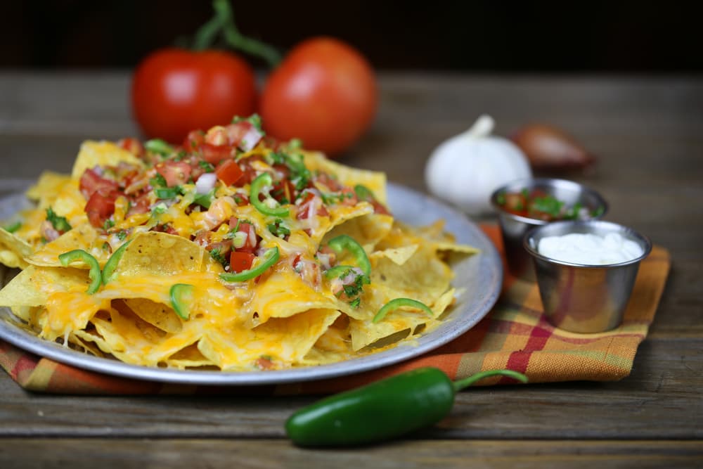 Ahora sí, es hora de rociar la salsa sobre los totopos, seguida de la carne y el pico de gallo. ¡Que delicia! Seguro nadie podrá parar de comer nachos.