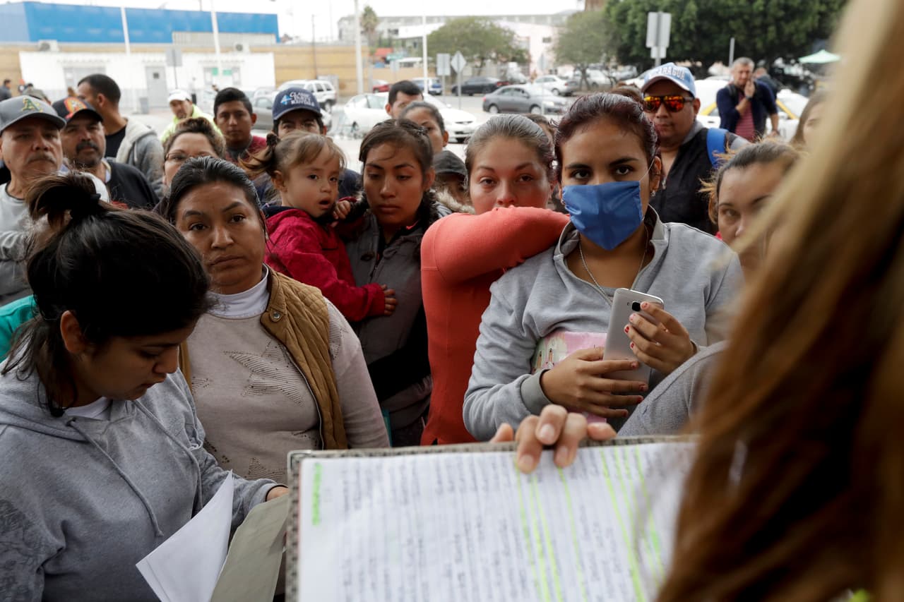 Los Grupos Beta también vigilan por la noche los desvencijados cuadernos donde se anotan las listas y los entregan a los voluntarios que durante el registrarán a los recién llegados. Esta imagen de migrantes intentando anotarse en la lista en Tijuana fue tomada en octubre de 2018.