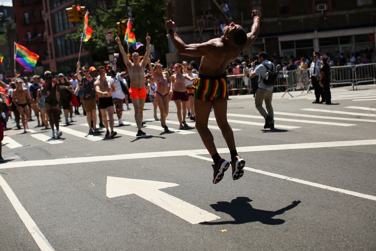 Un hombre salta mientras camina en la Marcha del Orgullo de Nueva York.