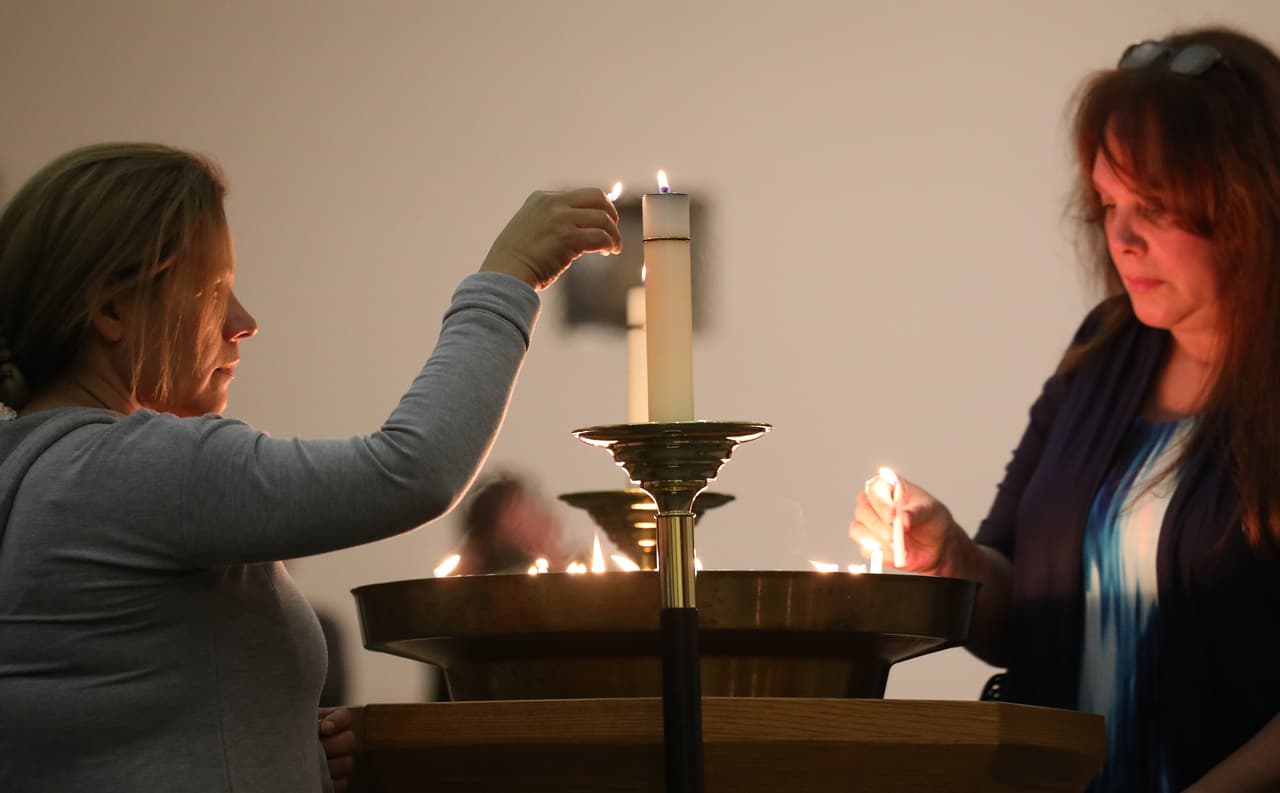 Una mujer enciende una vela en la iglesia episcopal St. Stephen's en honor a las víctimas mortales del tiroteo en la secundaria Saugus, en Santa Clarita, California.