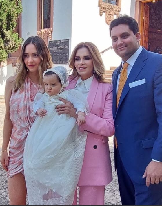La bebé vistió un ropón blanco, mientras que la orgullosa abuela optó por un elegante traje en color rosa con una blusa blanca.
<br>