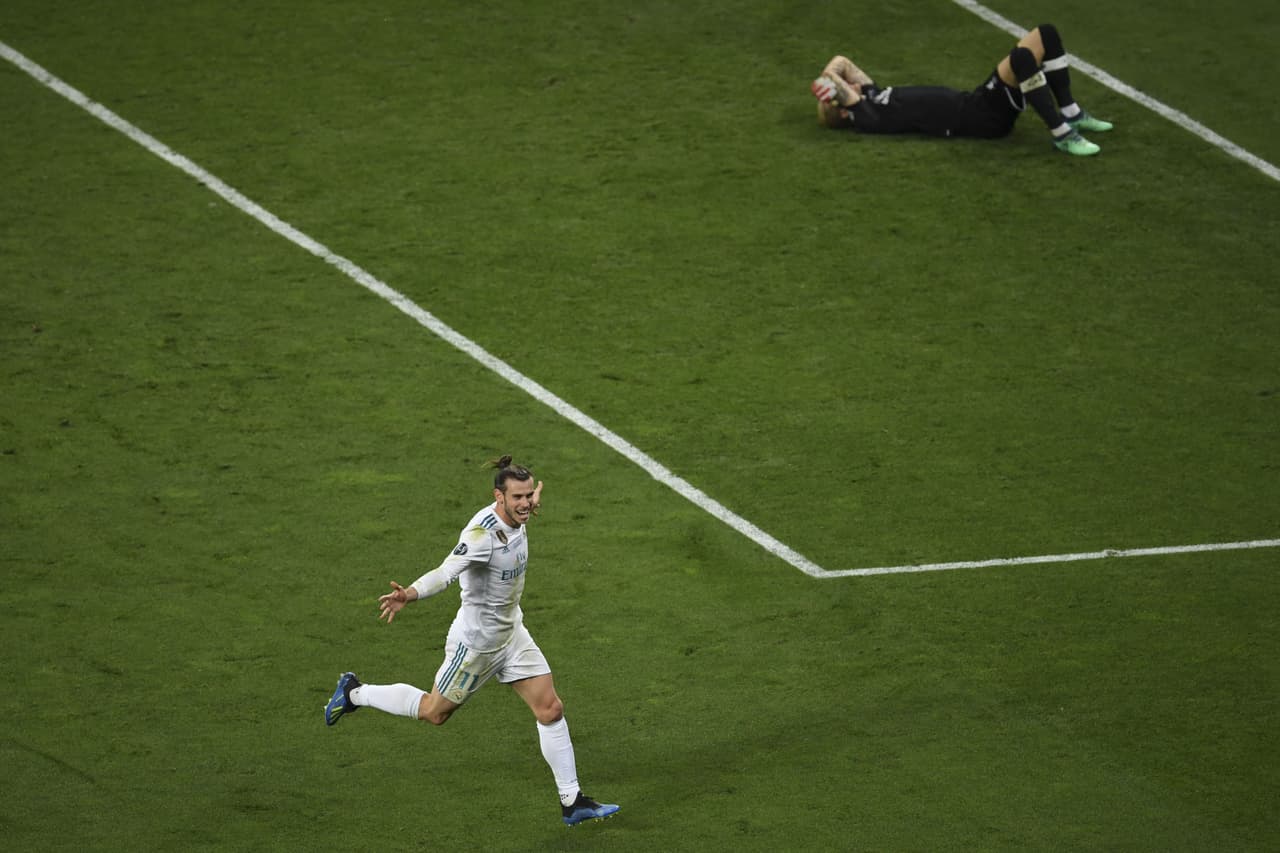 Real Madrid's Welsh forward Gareth Bale celebrates after scoring the the 3-1 against Liverpool's German goalkeeper Loris Karius (R) during the UEFA Champions League final football match between Liverpool and Real Madrid at the Olympic Stadium in Kiev, Ukraine on May 26, 2018. (Photo by Sergei SUPINSKY / AFP) (Photo credit should read SERGEI SUPINSKY/AFP/Getty Images)
