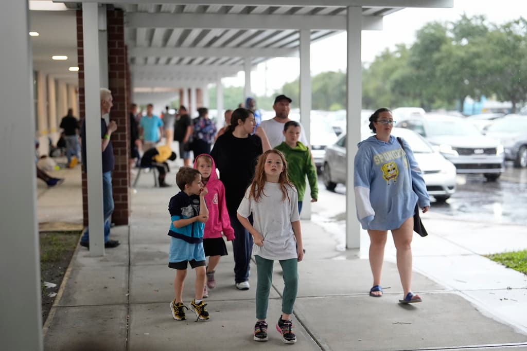 <b>Familia busca protección: </b>Por la mañana, familias llegaron a un refugio antitormentas del gobierno en la escuela secundaria Gibbs antes de decidir regresar a casa para enfrentar el huracán Milton, el miércoles 9 de octubre de 2024, en St. Petersburg, Florida.