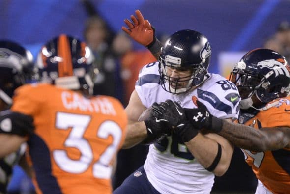 Los Seahawks, con un fútbol "total", el que había trabajado el entrenador del equipo durante toda la temporada regular, el veterano Pete Carroll, derrotaron por paliza de 43-8 a los Broncos, la mejor ofensiva de liga, con el mariscal de campo Peyton Manning a la cabeza. No habían pasado ni 12 segundos desde el comienzo del partido y los Seahawks ya hicieron historia con la anotación más rápida que se había dado jamás en un Super Bowl. Pero lo peor no fue el dejarse anotar dos puntos, sino la imagen de enfrentamiento entre Manning y el centro de origen mexicano Manny Ramírez, que no le dio bien al balón, y aunque el corredor Knowshon Moreno lo recuperó, lo hizo en la zona de protección. La mejor ofensiva de la NFL estaba paralizada, sin saber qué hacer, y ahí fue el comienzo y el final del partido disputado en el MetLife Stadium, de East Rutherford (Nueva Jersey), donde la temperatura fue de 43 grados. Malcom Smith recibió el premio de Jugador Más Valioso (MVP), el octavo defensor que lo consigue en un partido de Super Bowl y el tercer apoyador. Carroll, de 61 años, el tercer entrenador con más edad de la NFL que ganó un Super Bowl, se convirtió en el tercer entrenador que logra los dos títulos de campeón universitario de la NCAA con el equipo de USC y ahora los Seahawks en la NFL.