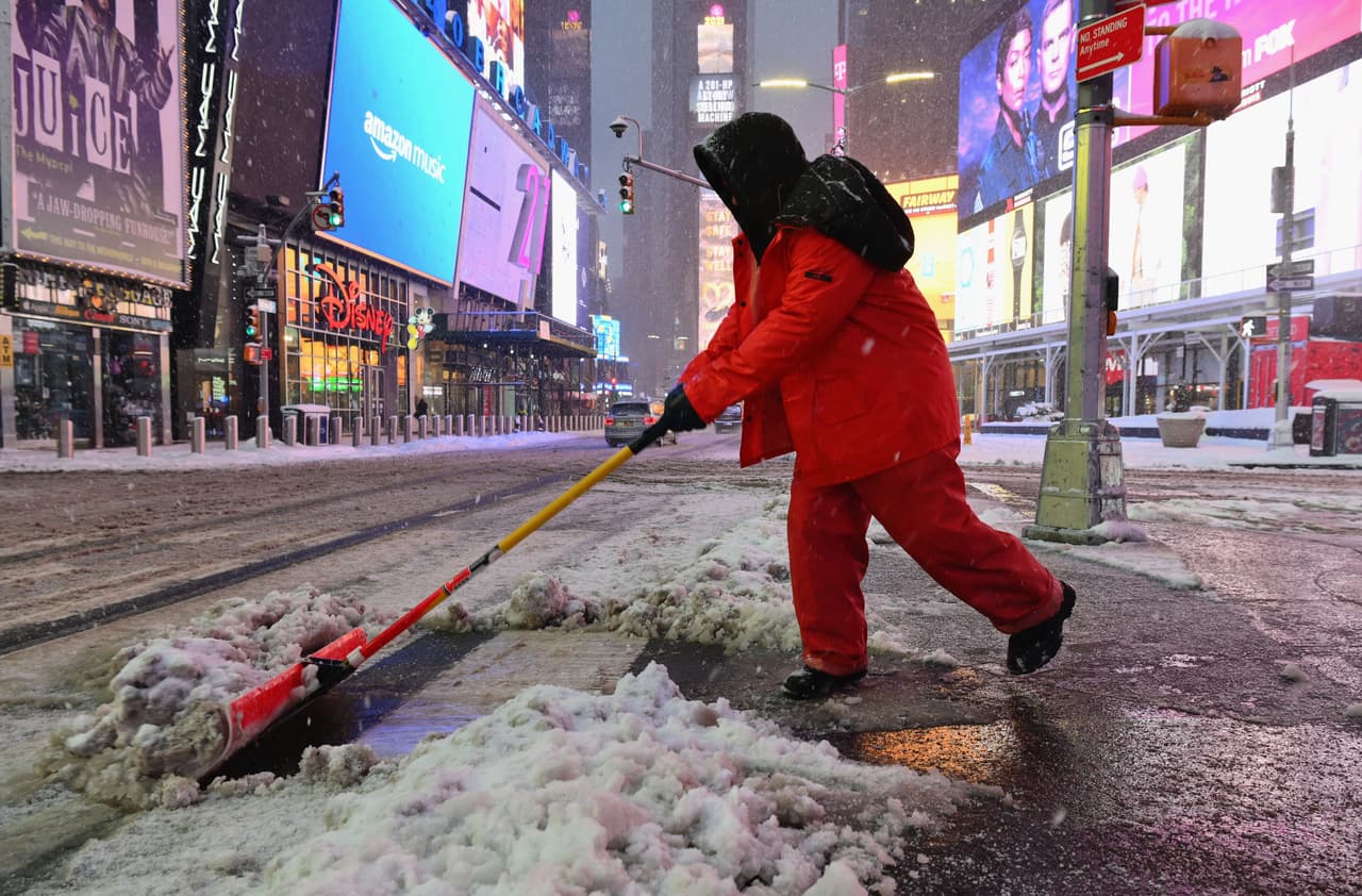 Un trabajador de la ciudad paleando nieve en Times Square, Nueva York, en la mañana del 1 de febrero. En el Aeropuerto La Guardia el 81% de los vuelos fueron cancelados y en el de Newark al menos el 75%.
<br>