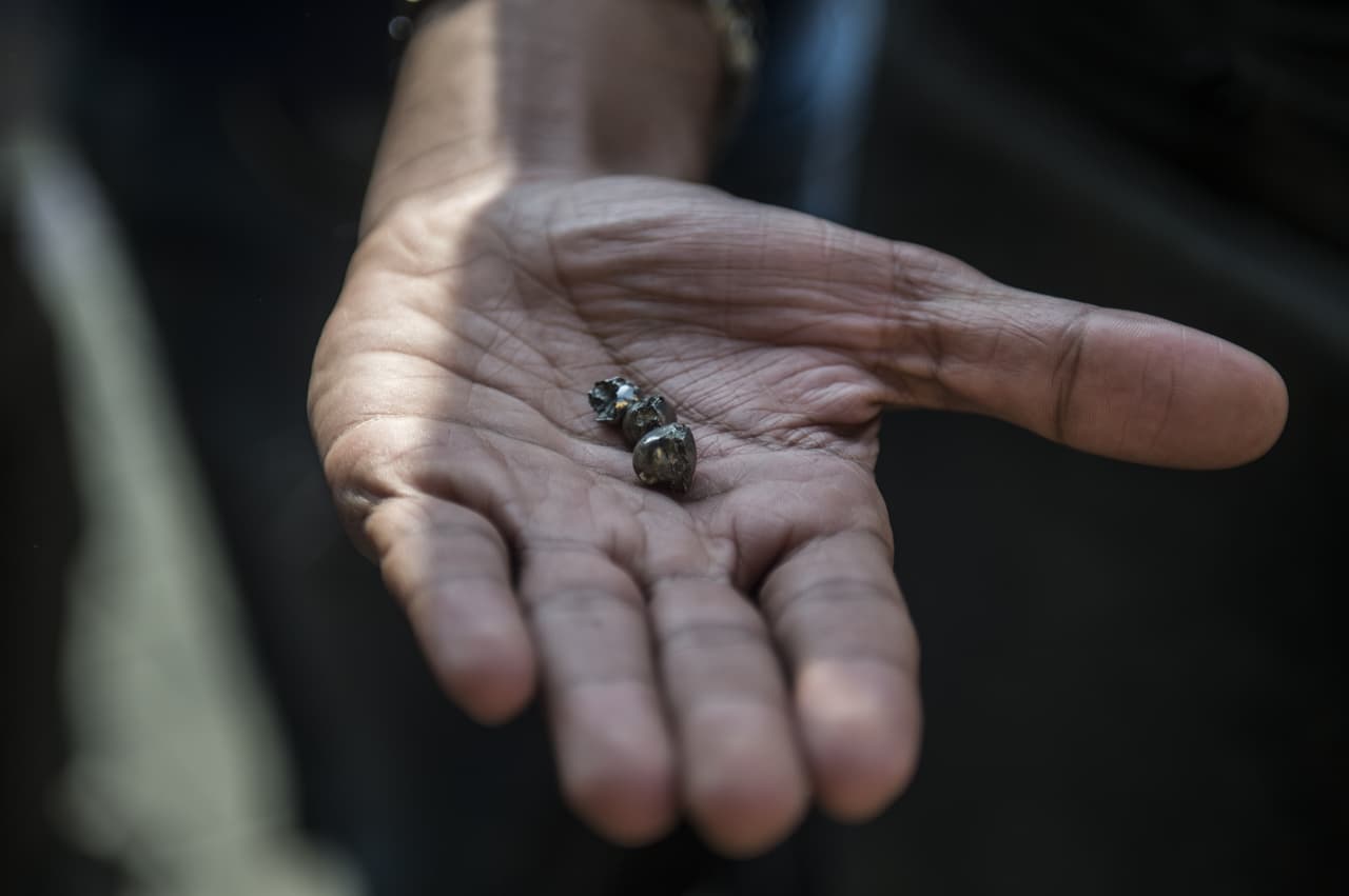 Un hombre muestra pequeños trozos de metal fuera de la Iglesia Ortodoxa Copta de San Pedro y San Pablo.