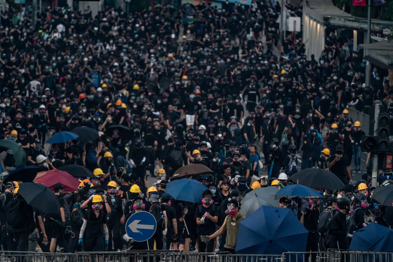 Miles de manifestantes vestidos de negro, algunos con máscaras de Guy Fawkes (inspiradas en el cómic "V de Vendetta" y popularizadas por el colectivo Anonymous), marcharon desde Causeway Bay desafiando la prohibición de manifestarse.
<br>
<br>