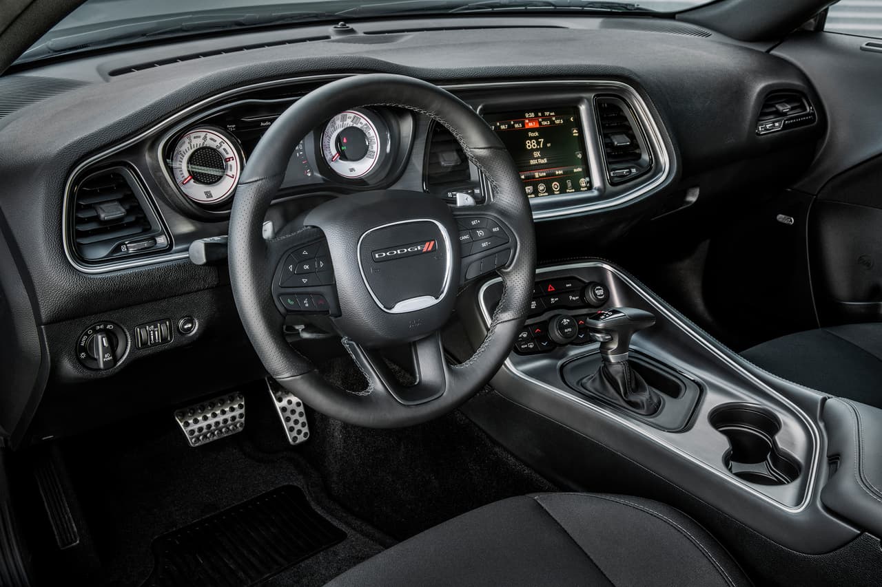 El interior del Dodge Challenger T/A 2017 es un templo para los entusiastas del manejo con unas enormes butacas reforzadas con soportes laterales, una instrumentación super completa altamente configurable y un volantes deportivo con paletas de cambios.
