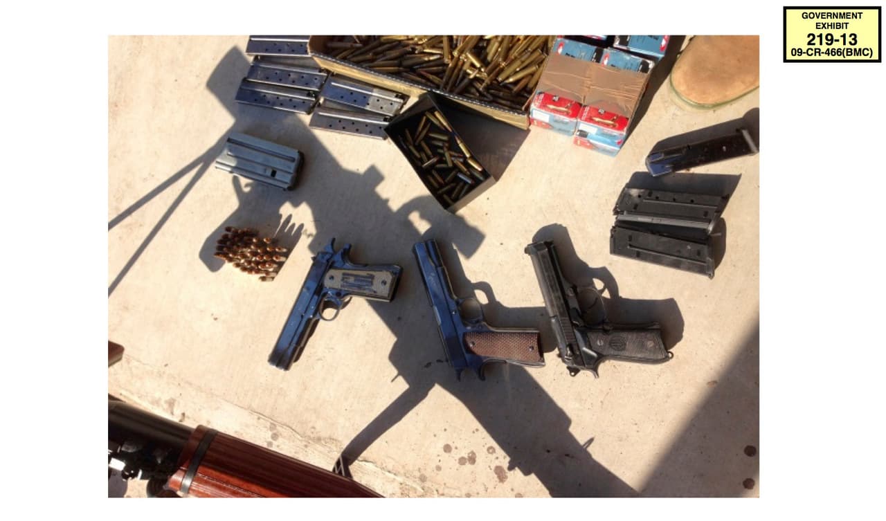 En esta foto la Fiscalía mostró un alijo de armas y municiones decomisadas por las autoridades mexicanas al cartel de Sinaloa en uno de los operativos para recapturar al narcotraficante Joaquín Guzmán Loera en 2014. La primera pistola a la izquierda lleva sus iniciales, JGL.
