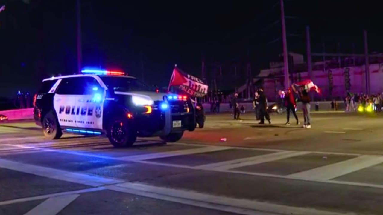 Entre gritos, pancartas y banderas, algunas con mensajes como “Libre Palestina”, manifestantes rodean una patrulla de la Policía de Dallas.
