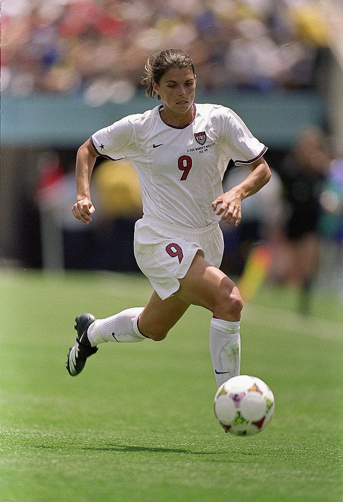 Mia Hamm de los Estados Unidos, para muchos la mejor de todos los tiempos, corre con el esférico mostrando su técnica eante el equipo de China en el Rose Bowl el 10 de julio de 1999 en Pasadena, California. Esa vez, el Team USA venció 5-4 a las chinas en un juego que se fue a la prórroga.