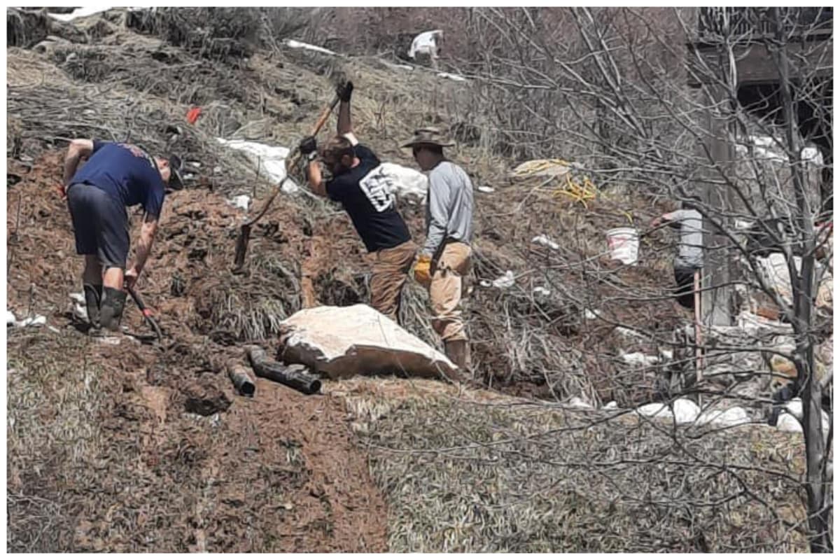 Bomberos y vecinos cavan zanjas para aliviar el flujo del agua.