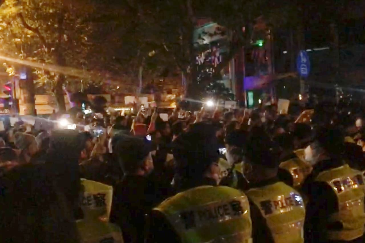 Imagen de un video obtenida por The Associated Press de la policía vigilando a los manifestantes en Shanghái este sábado, 26 de noviembre de 2022.