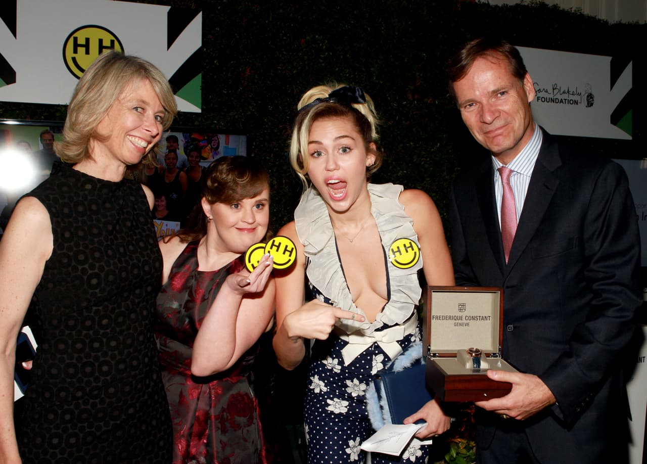 Miley y Jamie recibiendo su reconocimiento de manos de los organizadores, Aletta Stas-Bax y Peter Stas.