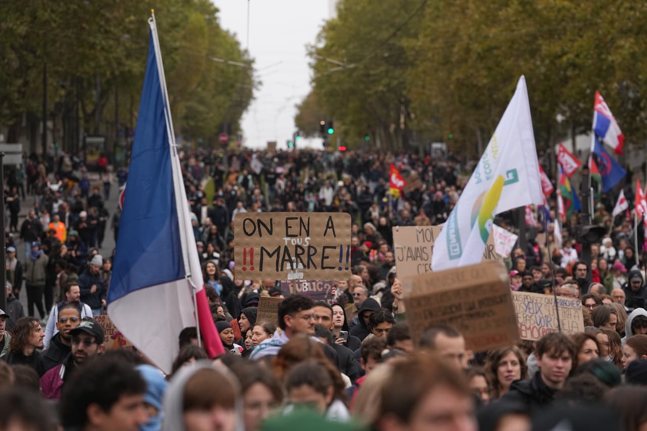 Manifestantes sostienen un cartel que dice "Estamos hartos" durante en las protestas del día de hoy en París, el sábado 24 de octubre de 2026.