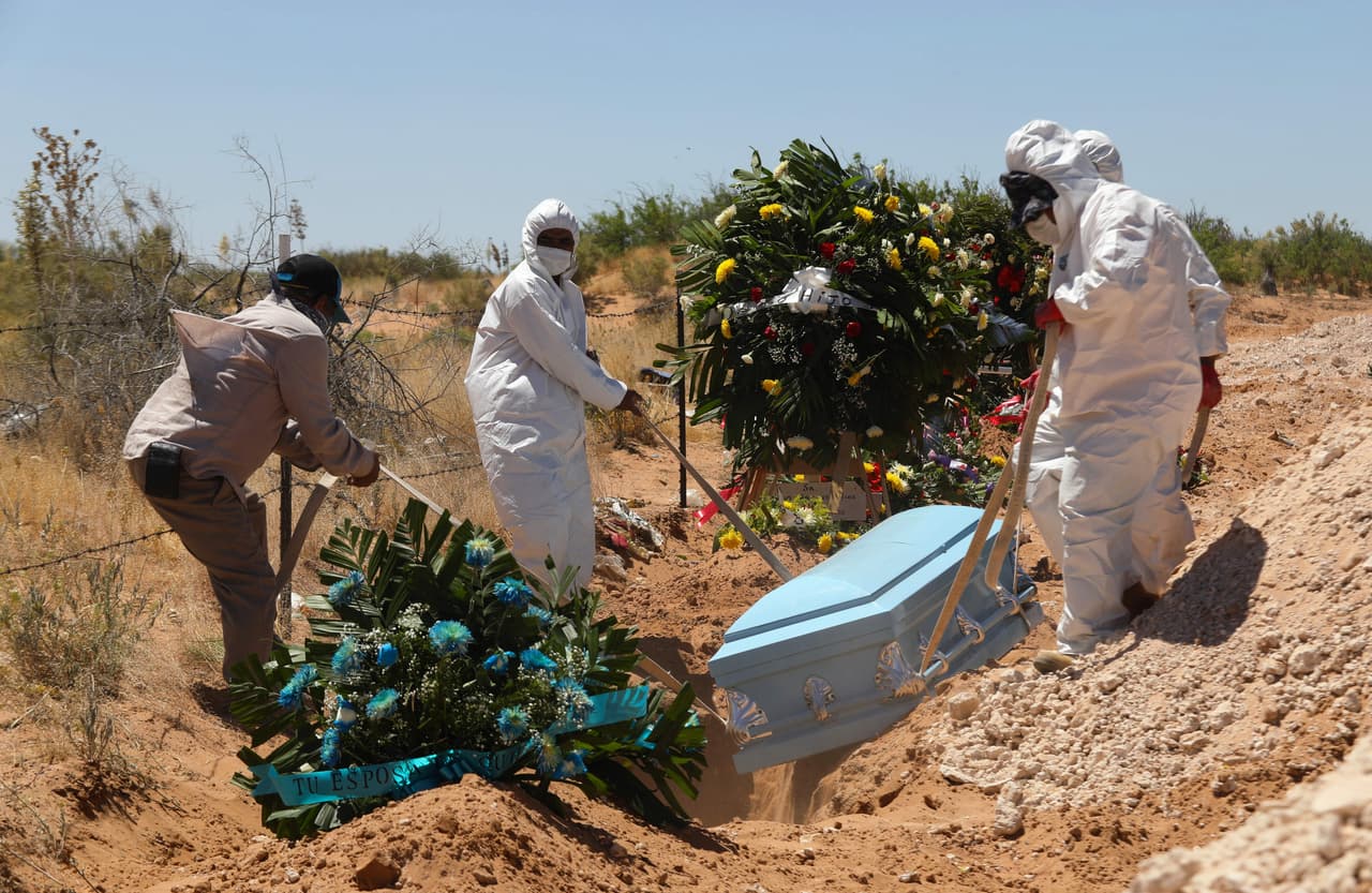 Enterradores del cementerio municipal de San Rafel en Ciudad Juárez transportan un ataúd a una zona reservada para fallecidos por coronavirus.